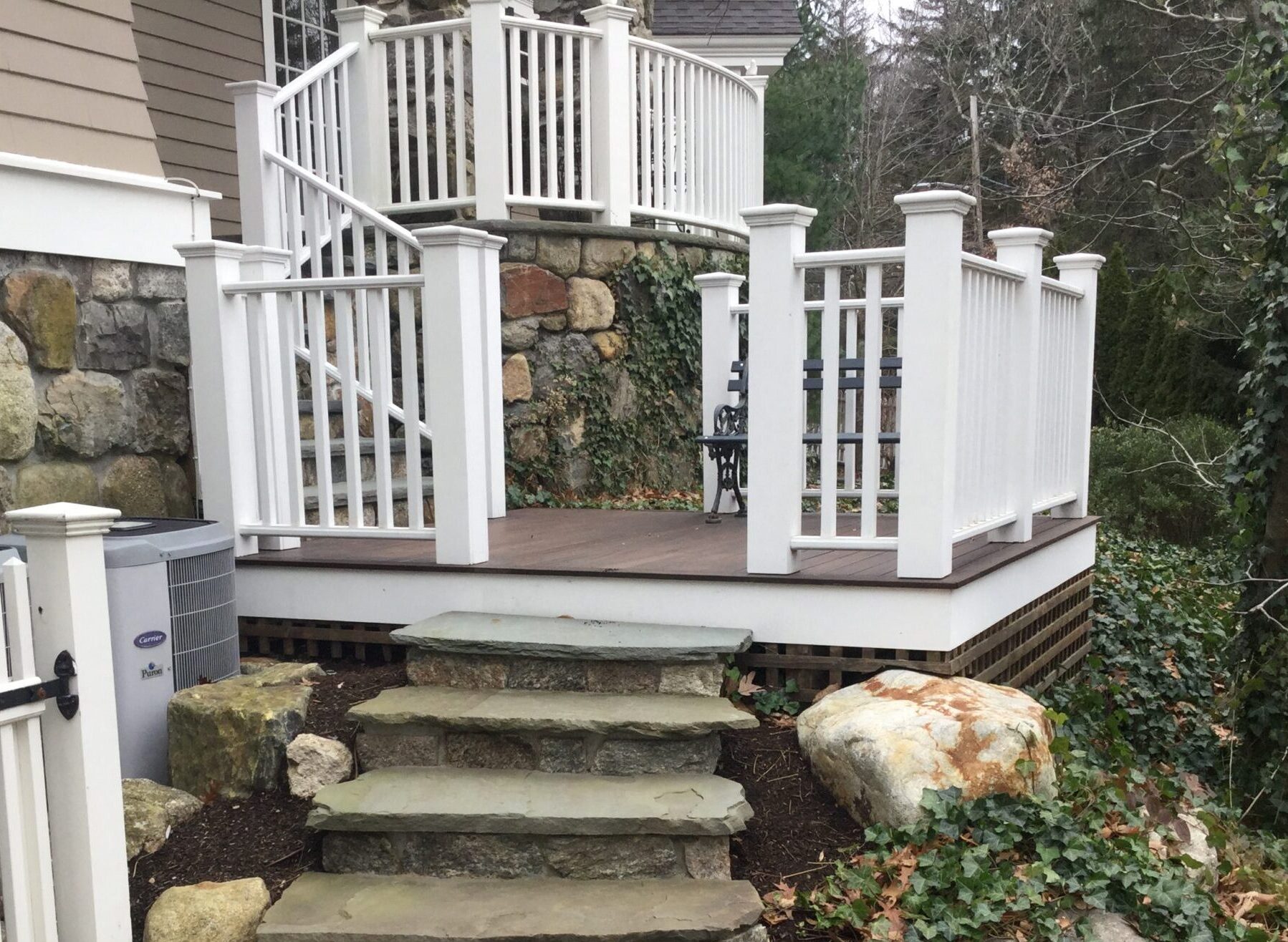 high end stone landscape design and general contracting boston: Custom carpentry mahogany wrap-around double tiered porch with natural fieldstone steps.